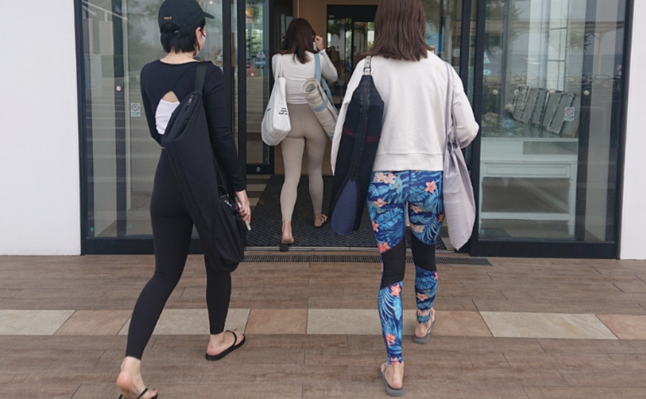 Walking into the yoga training venue with mats and bags